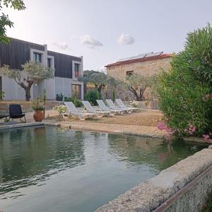 a row of lounge chairs next to a pool of water at Quinta Vale da Prata in Celorico da Beira