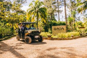 a golf cart driving down a dirt road at Gaia Riverlodge in San Ignacio +37 photos