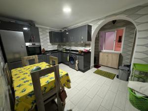 a kitchen with a table with a yellow table cloth on it at City Apartment in M'diq