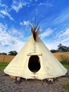 a white teepee with a ladder inside of it at Teepee Camp Lounky in Chodouny