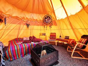 a bedroom with a tent with a bed and chairs at Teepee Camp Lounky in Chodouny +20 photos