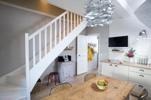 cocina y comedor con mesa y escalera en Appartement vue port, en Port-en-Bessin-Huppain