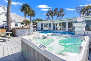 a hot tub on a deck next to a house at Bay Shore in Panama City Beach