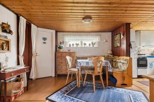 a kitchen with a table and chairs in a room at Stuga på ringsjös camping in Hörby