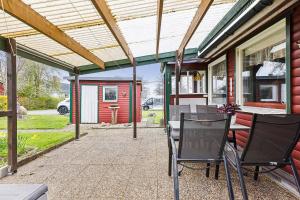 a patio with a table and chairs on a house at Stuga på ringsjös camping in Hörby