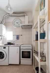 a kitchen with a stove and a clock on the wall at Casa dos Mastros in Lisbon