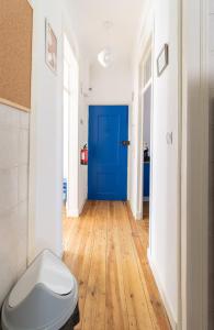 a bathroom with a toilet and a blue door at Casa dos Mastros in Lisbon