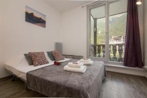 a bedroom with two beds and a large window at Chamonix Sud - Forclaz 213 - happy Rentals in Chamonix-Mont-Blanc