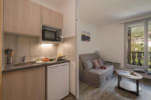 a kitchen with a sink and a couch in a room at Chamonix Sud - Forclaz 213 - happy Rentals in Chamonix-Mont-Blanc