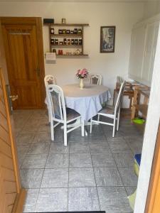 a kitchen with a table and chairs with a vase on it at Holzhaus "Miri" in Pirna +8 photos