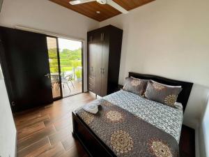 a bedroom with a bed and a door to a balcony at VillaVerde Beach House in Quebrada Ganado +16 photos