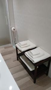 due asciugamani piegati su un tavolo in un bagno di B&B "La Dimora delle Gravine" a Gravina in Puglia
