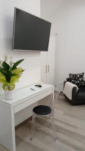 una scrivania bianca con sedia e una TV a parete di B&B "La Dimora delle Gravine" a Gravina in Puglia
