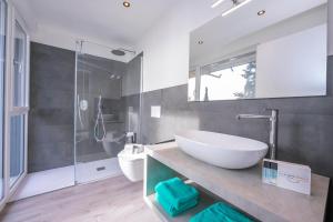 łazienka z białą umywalką i toaletą w obiekcie Rustichel Fantastic Lake View - Happy Rentals w mieście Toscolano Maderno +25 zdjęć