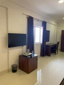 Uma televisão e/ou sistema de entretenimento em Tahir Guest Palace Suites