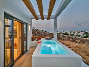 a bathtub in a room with a view of the city at Villa Sol Cielo Naousa Paros in Naousa