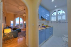 a kitchen with blue cabinets and a living room at Villa MonTLilin - Happy Rentals in Villefranche-sur-Mer
