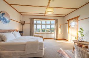 a bedroom with a bed and a large window at Lake Brunner Eco Lodge in Moana