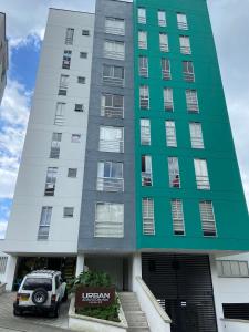 a building with a car parked in front of it at Edificio Urban Frente universidad Autónoma in Manizales
