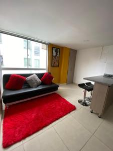 a living room with a black couch and a red rug at Edificio Urban Frente universidad Autónoma in Manizales