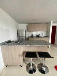 a kitchen with a counter and two bar stools at Edificio Urban Frente universidad Autónoma in Manizales