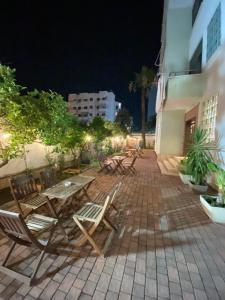 a group of chairs and tables on a patio at night at Green Garden Villa in Durrës