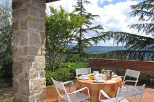 une table et des chaises sur une terrasse avec vue dans l'établissement Casa Citille - Happy Rentals, à Greve in Chianti