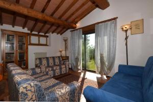 - un salon avec des canapés bleus et une grande fenêtre dans l'établissement Casa Citille - Happy Rentals, à Greve in Chianti