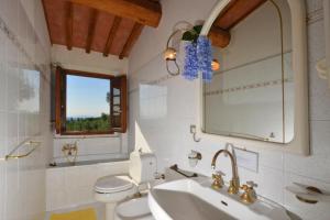 a bathroom with a sink and a toilet and a mirror at Casa Citille - Happy Rentals in Greve in Chianti +32 photos
