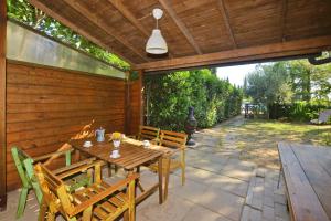 a wooden table and chairs on a patio at Casa Guna - Happy Rentals in Asciano