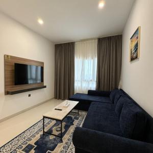 a living room with a couch and a tv at واجهة السعادة للشقق الفندقية in Salalah