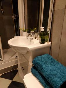 a bathroom with a white sink and a blue towel at Appartement moderne à Clichy, 35 m², idéal pour 4 personnes. in Clichy
