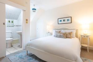 インバネスにあるLachie's Townhouseの大きなベッドとバスルームを備えた白い寝室