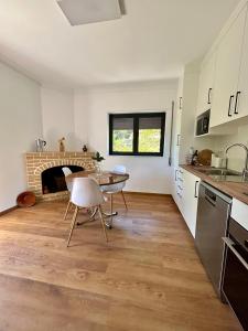 a kitchen and dining room with a table and a fireplace at Casa de Fráguas in Arouca +19 photos