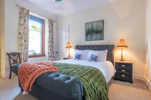 a bedroom with a bed and a couch and a window at Lachie's Townhouse in Inverness