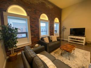 a living room with a couch and a tv at Cozy 3br Downtown Bakery & Shops! in La Crosse
