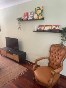 a living room with a chair and a flat screen tv at Figueroa Apartments in Pontevedra