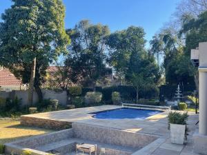 a swimming pool in a yard with trees at OneOnArum in Johannesburg