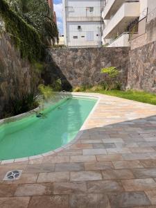 a pool of green water next to a building at De lo mejor en Barrio General Paz in Cordoba