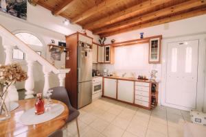a kitchen with wooden ceilings and a table and a refrigerator at Yiannis' Maizonette Ancient Olympia - Happy Rentals in Olympia