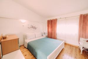 a bedroom with a bed and a desk and a window at Yiannis' Maizonette Ancient Olympia - Happy Rentals in Olympia