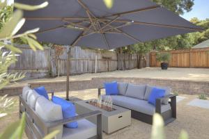 eine Terrasse mit einer Couch und einem Sonnenschirm in der Unterkunft 3944 Seaside Bash home in Carmel