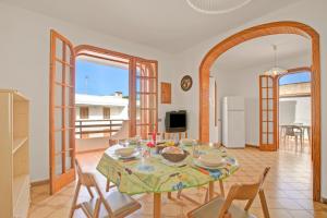 a kitchen and dining room with a table and chairs at Casa Marangi 250 meters from the sea - Happy Rentals in Melendugno