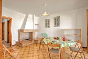 a dining room with a table and a fireplace at Casa Marangi 250 meters from the sea - Happy Rentals in Melendugno
