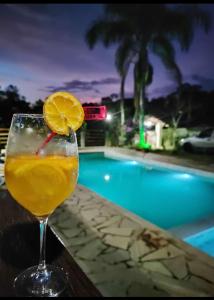 a drink sitting on a table next to a pool at Chácara Rancho Imperial - Socorro - SP - Piscina, Churrasqueira, Forno à Lenha, Campo de Futebol e uma linda Vista para a Montanha! in Socorro
