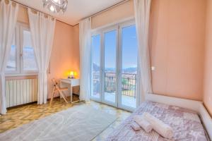 une chambre avec un lit et une grande fenêtre dans l'établissement Zio Enry Terrace Apartment Orta Lake - Happy Rentals, à Armeno 34 autres photos