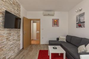a living room with a gray couch and a brick wall at Holiday Home Aurea - Happy Rentals in Labin