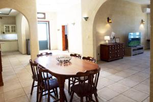 a dining room with a wooden table and chairs at Zest Gozitan Villa & Pool - Happy Rentals in Qala