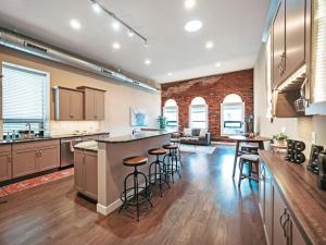 an open kitchen with a bar with stools at Cozy 3br Downtown Bakery & Shops! in La Crosse