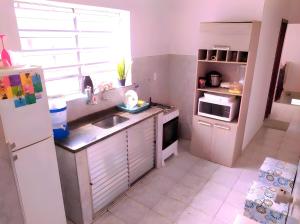 a small kitchen with a sink and a refrigerator at Conexão SP in São Paulo